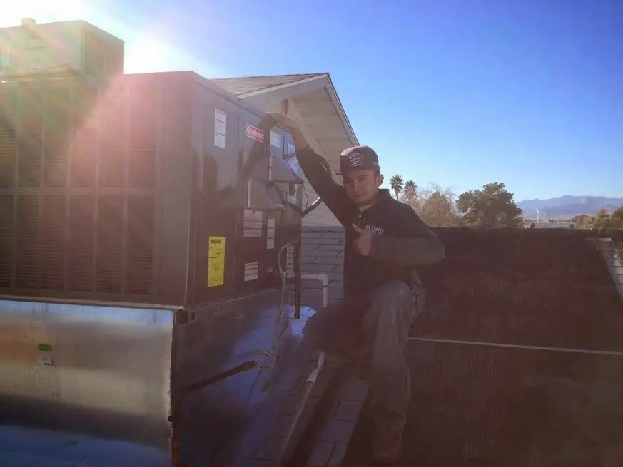 HVAC technician performing HVAC Inspection on a rooftop unit in Krum
